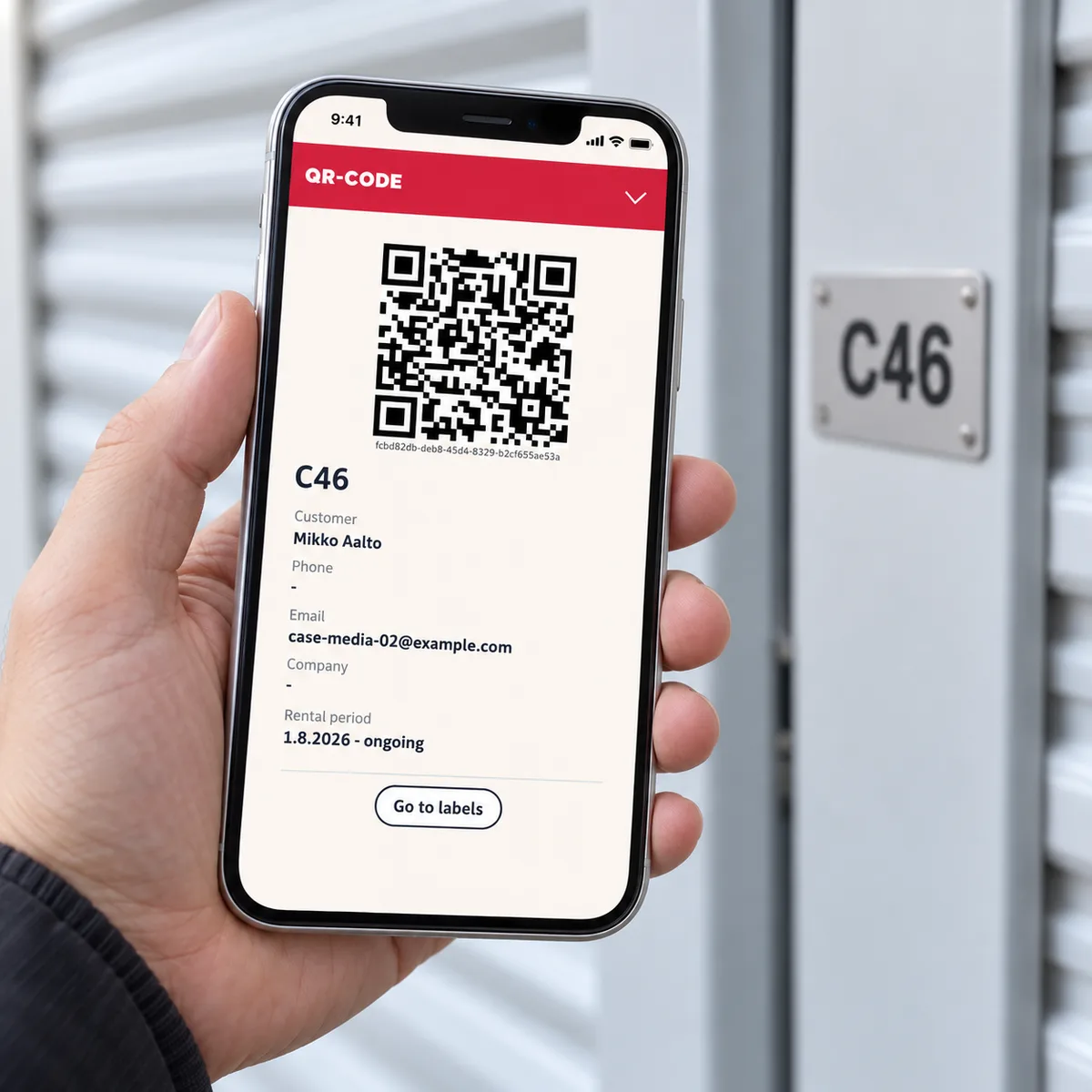En telefon visar en QR-etikett för demouthyrning vid en illustrativ förrådsdörr.