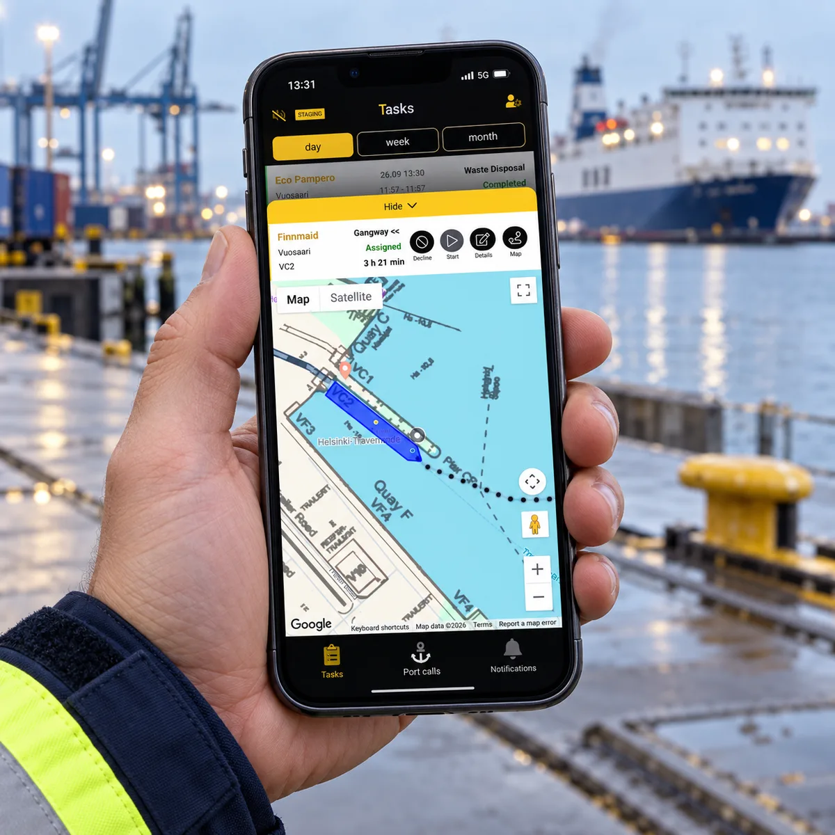 Illustrativ hamnarbetare håller en telefon med PortLinks karta över fartyg och kajplats.